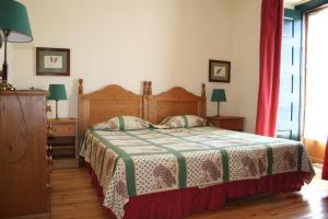 um quarto com uma cama com um cobertor verde e branco em Casa da Arvore em Marvão