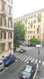 eine Stadtstraße mit Autos auf einem Parkplatz in der Unterkunft Nova Roma Guest House in Rom