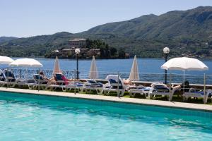 un gruppo di persone sdraiate su sedie accanto alla piscina di Hotel San Rocco a Orta San Giulio