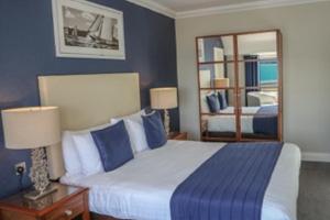 a bedroom with a large bed and a mirror at Haven Hotel in Poole