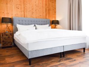 una camera da letto con un grande letto bianco con due lampade di Donau Lodge Boardinghouse a Straubing