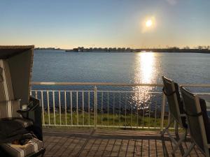 a view of the water from a porch with two chairs at Schleivilla Hafenmeister in Kappeln