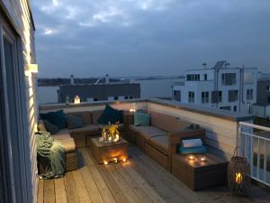 a rooftop patio with a couch and a table at Schleivilla Hafenmeister in Kappeln