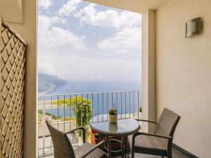 a balcony with a table and chairs and a view of the ocean at Hotel Villa Fraulo in Ravello