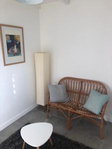 un banco con 2 almohadas y una mesa en una habitación en Agréable appartement à 2 pas des plages, en Le Gosier