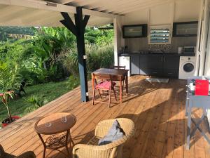 una terraza de madera con mesa y sillas en Agréable appartement à 2 pas des plages, en Le Gosier