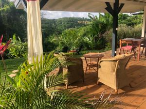 una terraza de madera con sillas y una mesa con vistas en Agréable appartement à 2 pas des plages, en Le Gosier