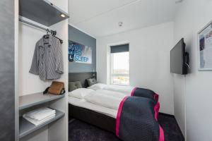 una piccola camera con letto e televisore di Cabinn Copenhagen a Copenaghen