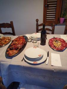 a table with plates of food and a pizza at B&B Perdalonga in Ghilarza