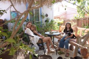 een groep mensen die in stoelen op een patio zitten bij Or Gani in Arad