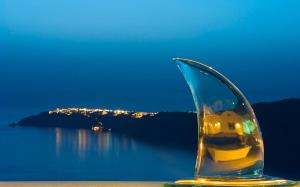 a glass vase sitting on a table next to the water at White Santorini in Imerovigli