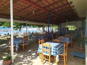 restauracja z niebiesko-białymi stołami i krzesłami w obiekcie Makinia Beach w mieście Nafpaktos