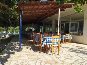 restauracja ze stołem i krzesłami pod pergolą w obiekcie Makinia Beach w mieście Nafpaktos