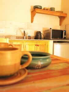 een keuken met een kom op een houten tafel bij Casatilcara Cabañas in Tilcara