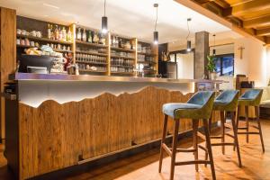 a bar with blue stools and a wooden fence at Gasthof Tuscherhof in Braies