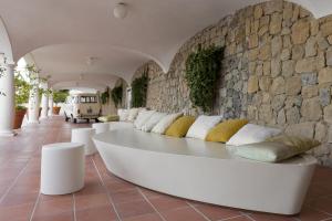 um sofá branco num quarto com uma parede de pedra em Villa Piedimonte em Ravello