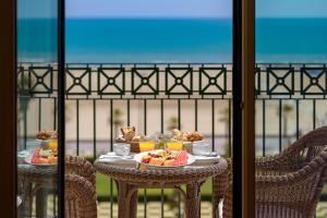 - une table avec de la nourriture sur le balcon dans l'établissement Las Arenas Balneario Resort, à Valence