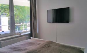 1 dormitorio con TV de pantalla plana en la pared en HOLI DAY SPA Appartement 1, en Berlín