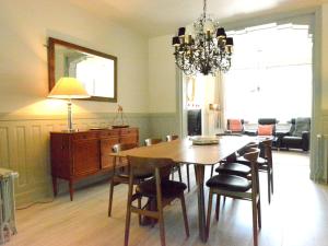 a dining room with a table and chairs and a chandelier at Large townhouse with pool table in Bouillon