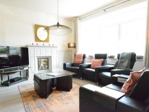 a living room with couches and a tv and a fireplace at Large townhouse with pool table in Bouillon