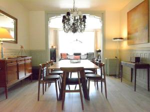 a dining room with a table and chairs and a chandelier at Large townhouse with pool table in Bouillon