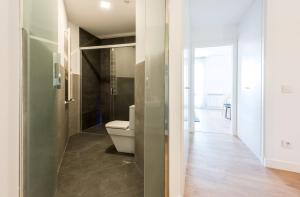 a bathroom with a toilet and a glass door at Plaza de España Skyline in Madrid