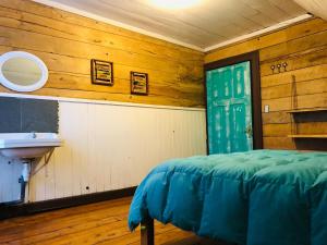 baño con lavabo y 1 cama en una habitación en Casa Apel Hostel, en Puerto Varas