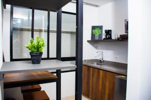 a kitchen with a table with a potted plant on it at Kapital Suites in Pereira