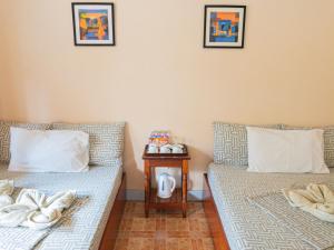 two beds sitting next to each other in a room at Inngo Tourist Inn in El Nido