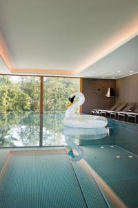 - une piscine avec un cygne dans une chambre dans l'établissement Minglers Sportalm - Das Gourmet- und Genießerhotel, à Kirchberg in Tirol