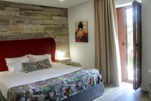 una camera con letto e parete in legno di Art'Otel Barcelos a Barcelos