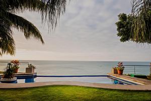 a swimming pool with the ocean in the background at Hotel Vistalmar in Manta