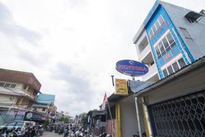 ein Gebäude mit einem Schild für ein Restaurant auf einer Straße in der Unterkunft Sentosa Guest House in Pontianak