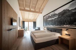 A bed or beds in a room at Alpinhotel Vajolet - Adults only