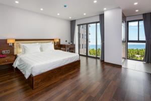 1 dormitorio con 1 cama grande y ventanas grandes en DANA RESIDENCE, en Da Nang