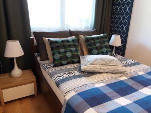 a bedroom with a bed with pillows and two lamps at Apartament Pruszków in Pruszków