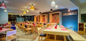 a restaurant with tables and chairs in a room at GINGER Noida City Center in Noida