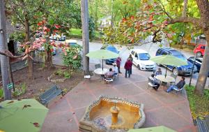 een groep mensen die aan tafels met paraplu's zitten bij Hotel Valles in Ciudad Valles