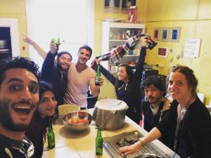 un gruppo di persone in piedi in una cucina con bottiglie di birra di Jack's Backpackers a Blenheim