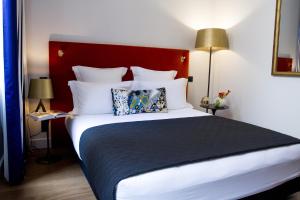 1 dormitorio con 1 cama grande y cabecero rojo en Hôtel Cardinal Bordeaux Centre, en Burdeos