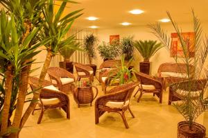 un restaurant avec des chaises en osier, des tables et des plantes dans l'établissement PRIMAVERA Hotel & Congress centre, à Plzeň