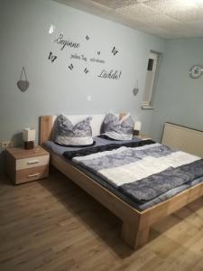 a bedroom with a bed with words on the wall at Ferienwohnung Preuß in Martinlamitz