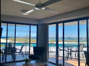 a living room with a ceiling fan and a view of the ocean at Centrepoint Apartments Caloundra in Caloundra