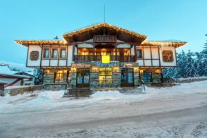 een gebouw aan de kant van een met sneeuw bedekte weg bij MPM Family Hotel Merryan in Pamporovo