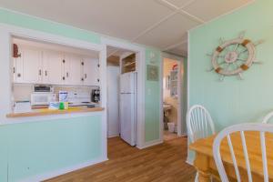 een keuken met een witte koelkast en een tafel bij The Eastern Avenue Cottage in Wells Beach