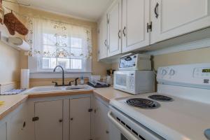 een keuken met een fornuis, een wastafel en een magnetron bij The Eastern Avenue Cottage in Wells Beach