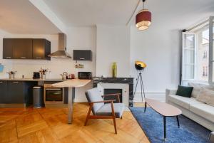 uma cozinha e sala de estar com uma mesa e um sofá em Le Cœur des Dominicains - pour 6 centre de Nancy em Nancy