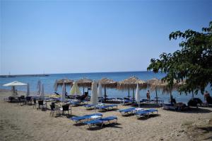 un grupo de sillas y sombrillas en una playa en Sotiras Rooms, en Skala Sotiros