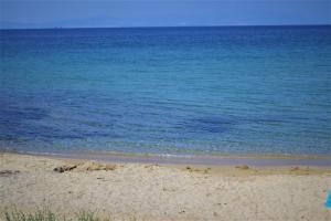 una playa de arena con el océano en el fondo en Sotiras Rooms, en Skala Sotiros