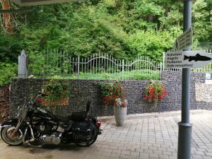 una motocicleta estacionada junto a una pared de ladrillo con flores en Parkhotel Forest, en Mariánské Lázně